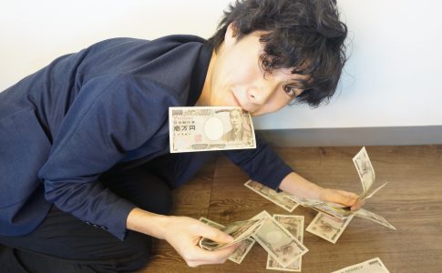 床で1万円札を数枚集める男性